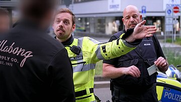 Auseinandersetzung zwischen Polizei in Uniform und einem Fahrer bei einer routinemäßigen Verkehrskontrolle